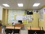 Робоче місце викладача та зона теоретичної підготовки водіїв в Ужгороді — дошка, комп'ютерна техніка та плакати з розпізнавальними знаками.