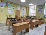 Світла та простора аудиторія для занять майбутніх водіїв в автошколі «Антарес» з куточком споживача та схемами будови автомобіля на стінах.